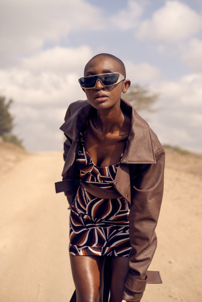 Outdoor fashion portrait of a woman in sunglasses and a leather jacket on a dirt road