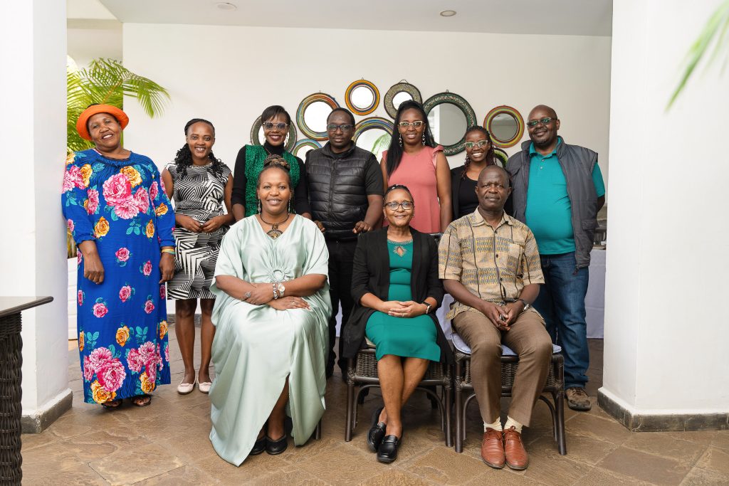 Group portrait of attendees seated and standing indoors